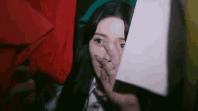 a woman is covering her face with her hand while taking a picture of herself in a photo booth .