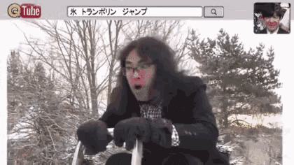 a man in a suit and gloves is riding a sled in the snow with a tube search bar above him