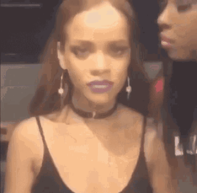 a close up of a woman wearing a choker and purple lipstick .