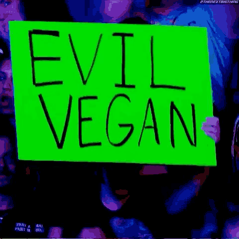 a group of people holding a sign that says evil vegan