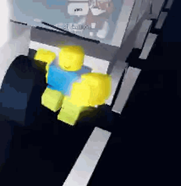 a yellow and blue lego man is walking down a street in a video game .