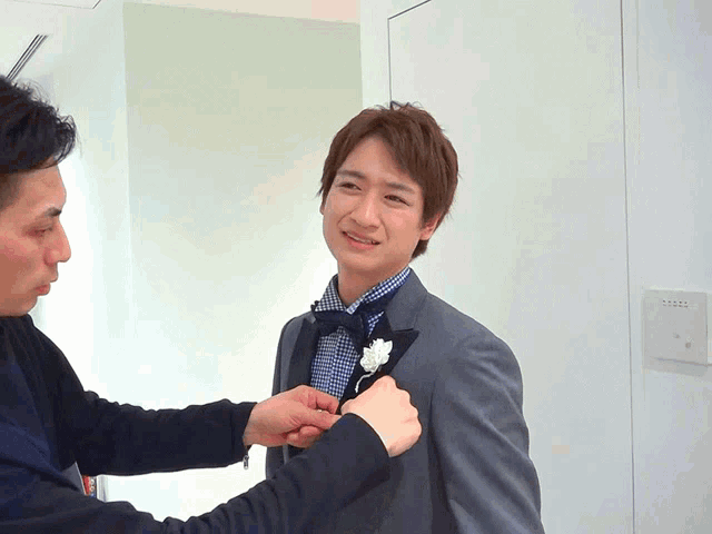 a man in a tuxedo has a flower in his pocket