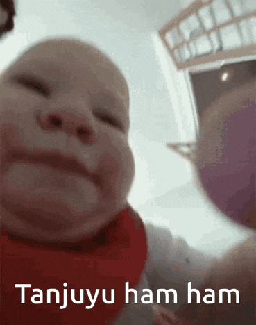 a close up of a baby 's face with the words " tanjuyu ham ham " written on the bottom