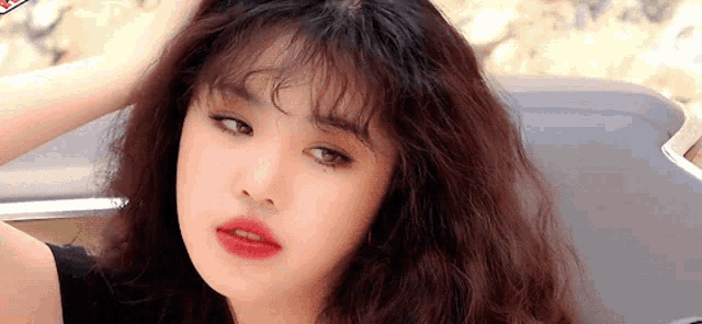 a close up of a woman 's face with curly hair .