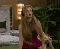 a woman with long hair is sitting on a bed in a room .