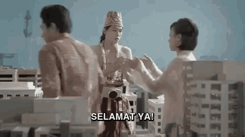 a group of people are standing next to each other in front of a city and a man is talking to a woman .