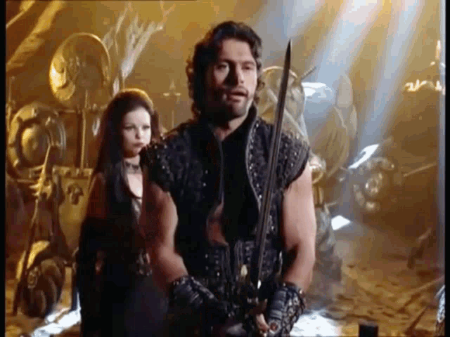 a man with a sword stands next to a woman with long hair