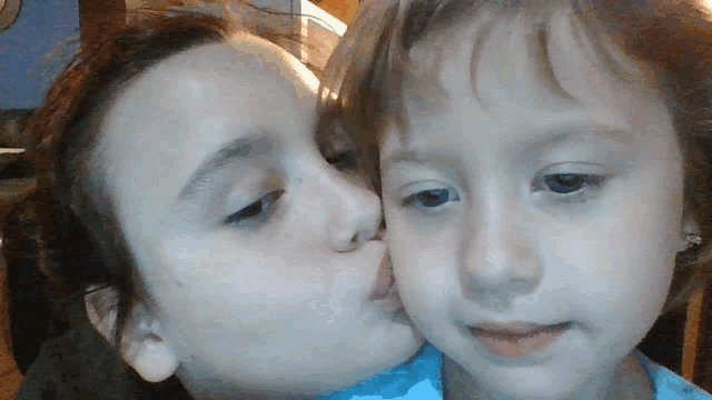 two little girls kissing each other on the cheeks