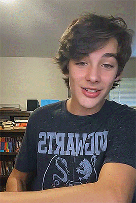 a young man wearing a black t-shirt that says 2t9aw20v
