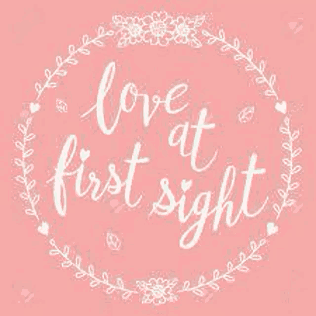 a pink background with the words `` love at first sight '' in a circle with flowers and hearts .