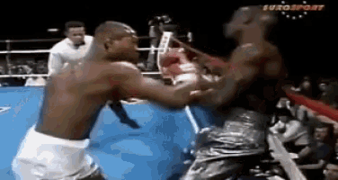 two men are fighting in a boxing ring with eurosport on the bottom