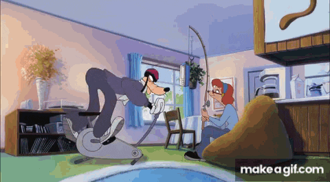 goofy is riding an exercise bike in a living room with a woman sitting on a bean bag chair .