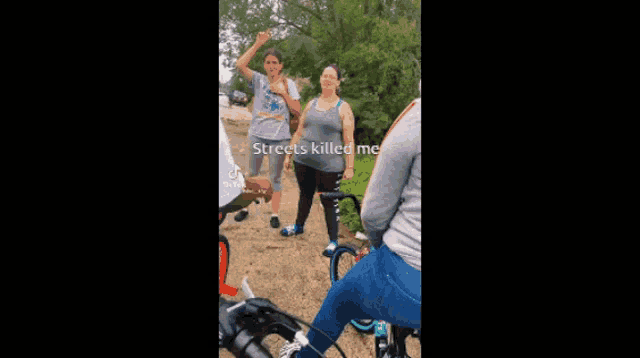 a group of people are standing next to each other on a dirt road with bicycles .
