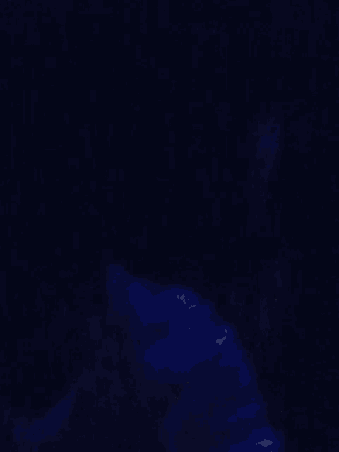 two women are sitting next to each other in a dark room and one has glasses on