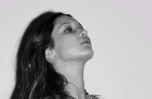 a close up of a woman 's face in a black and white photo against a white background .