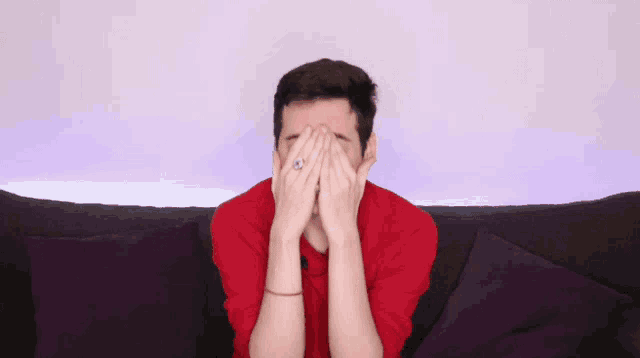 a man in a red shirt is clapping his hands