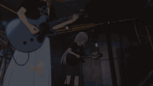 a girl is playing a guitar on a stage with a man playing a guitar behind her