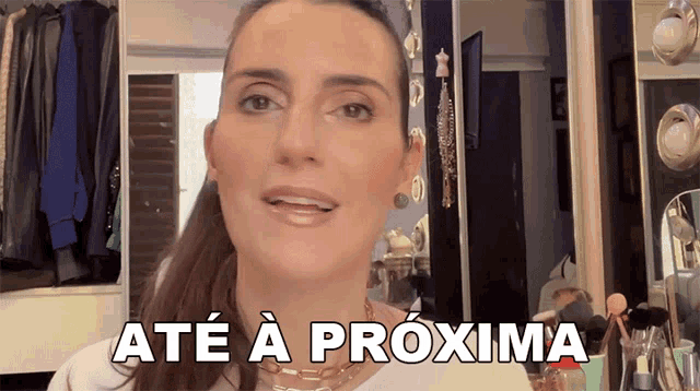 a woman says até a próxima in front of a closet