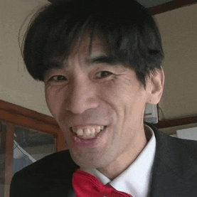 a man in a suit and tie is smiling and making a funny face .