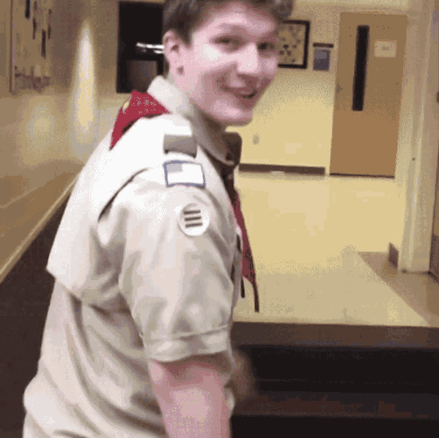 a boy scout in a hallway has a patch on his arm that says ' ii ' on it