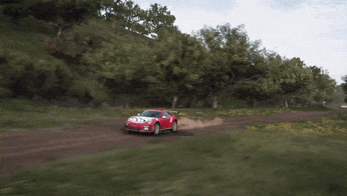 a red sports car is driving on a dirt road