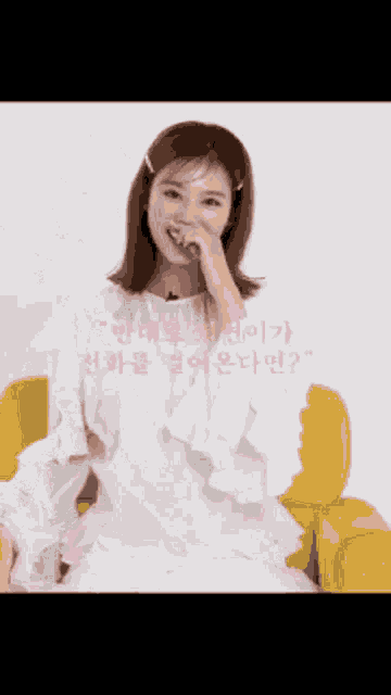a woman in a white shirt is sitting on a yellow couch .