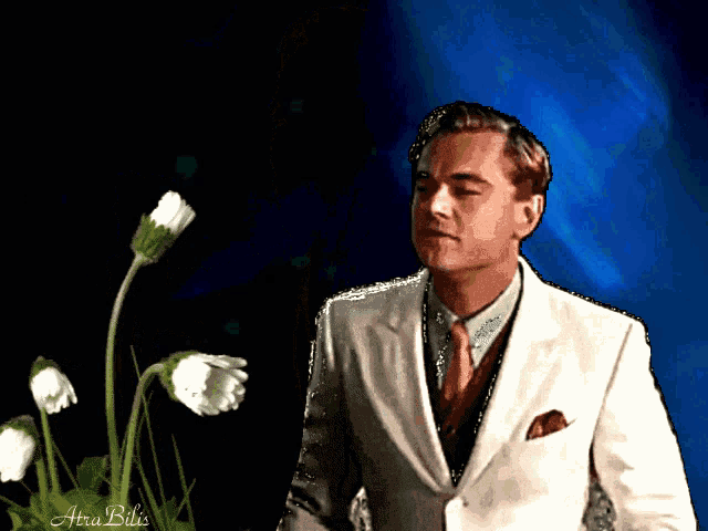 a man in a suit and tie is standing in front of some flowers with the name ara billa on the bottom right