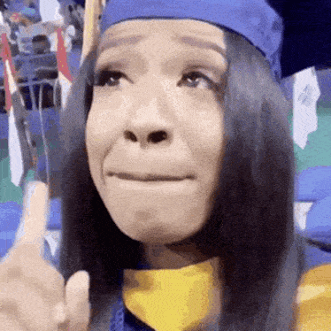 a woman wearing a graduation cap and gown is making a sad face .