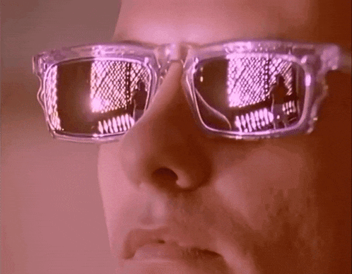 a close up of a person wearing sunglasses with a reflection of a building