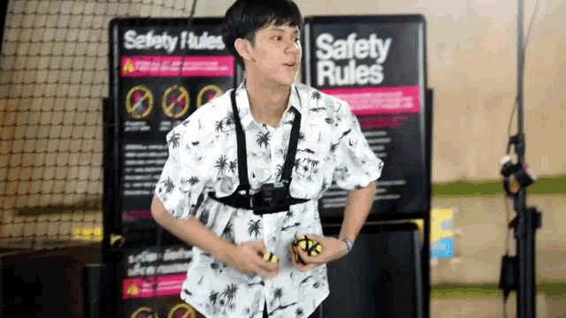 a young man stands in front of a sign that says safety rules