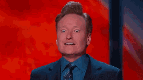 a man in a suit and tie is making a face