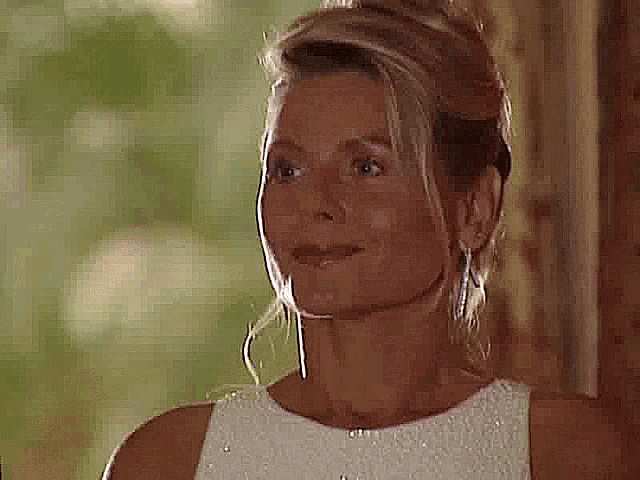 a woman in a white dress is smiling and looking to the side .