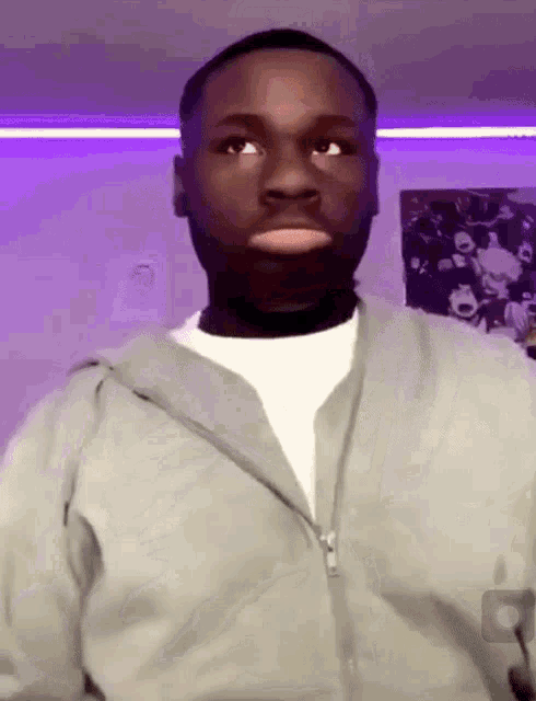 a man wearing a grey hoodie and a white shirt