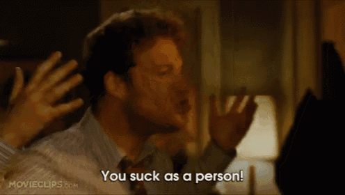 a man in a suit and tie is saying you suck as a person .
