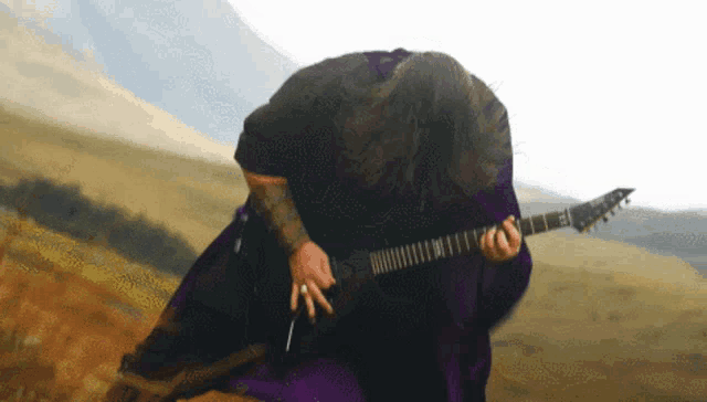 a man in a purple robe playing a guitar