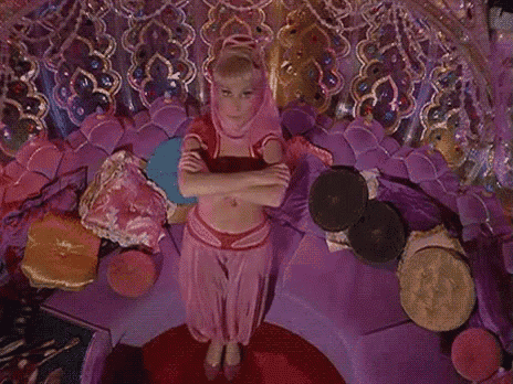 a woman in a pink costume is sitting on a purple couch .