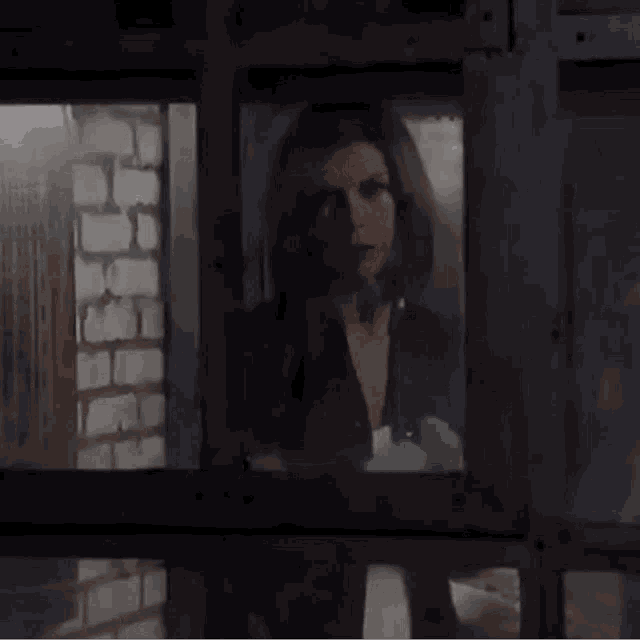 a woman is standing in front of a window holding a bottle of water .
