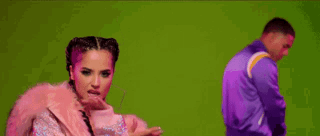a woman is wearing a pink fur coat and a man is wearing a purple jacket .