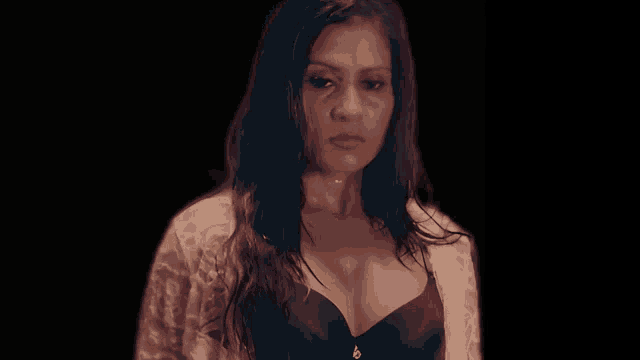 a woman in a black bra and a white robe looks at the camera