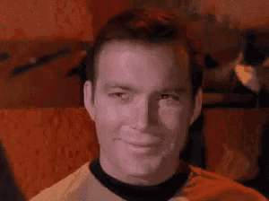 a close up of a man wearing a yellow shirt and black collar smiling .
