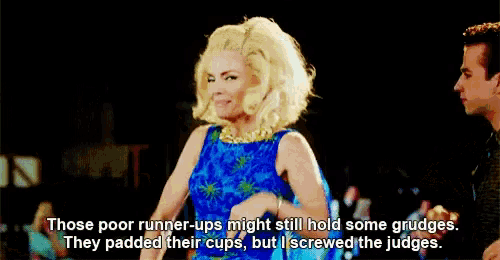 a woman in a blue dress is laughing and saying `` those poor runner-ups might still hold some grudges .