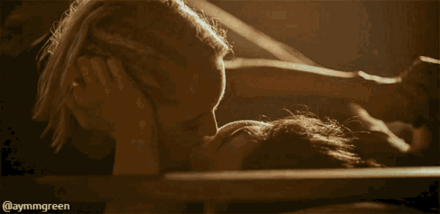 a woman is kissing another woman on the forehead in a close up