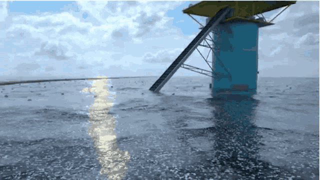 a tower in the middle of the ocean with a ladder leading up to it