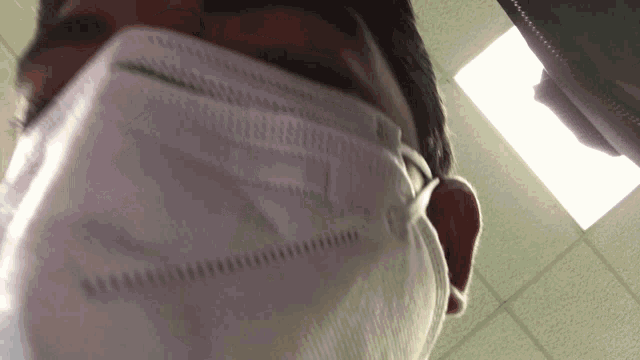 a man wearing a white face mask with a green stripe