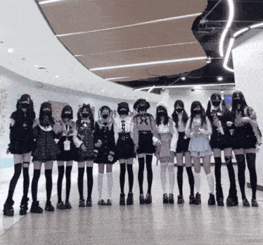 a group of girls wearing masks and knee high socks pose for a photo