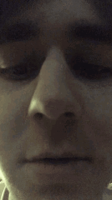 a close up of a person 's face with a serious look on his face