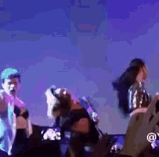 a group of people are dancing on a stage in front of a screen .