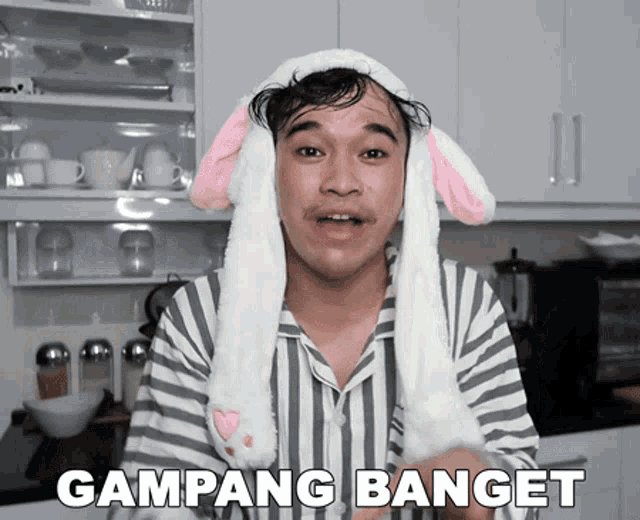 a man wearing a bunny hat says " gampang banget " in a kitchen