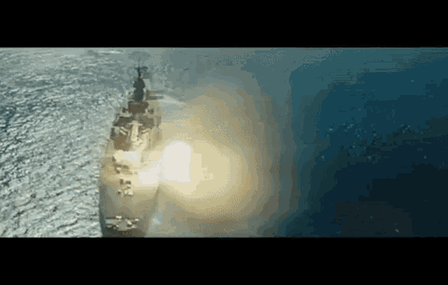 a large ship is floating on top of a body of water in the ocean .