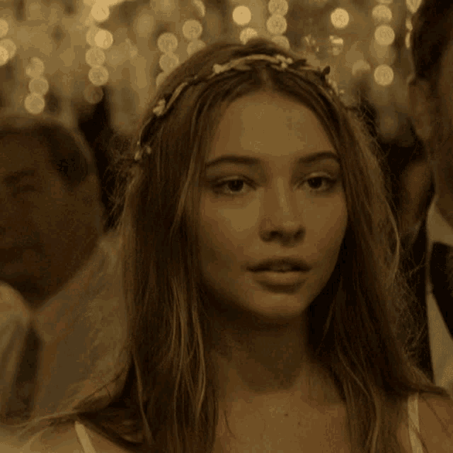 a close up of a woman 's face with a flower crown on her head
